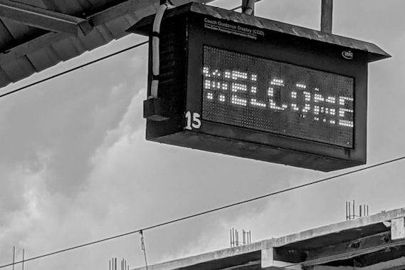 Eine Bahnhofsanzeige, auf der "Welcome" steht